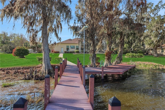 dock area with a lawn and a water view