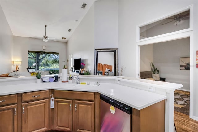 kitchen with sink, hardwood / wood-style flooring, stainless steel dishwasher, ceiling fan, and kitchen peninsula