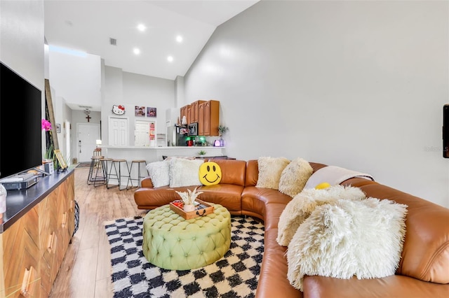 living room with high vaulted ceiling and light hardwood / wood-style floors