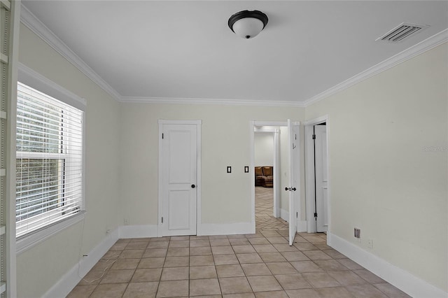 spare room with light tile patterned floors and crown molding