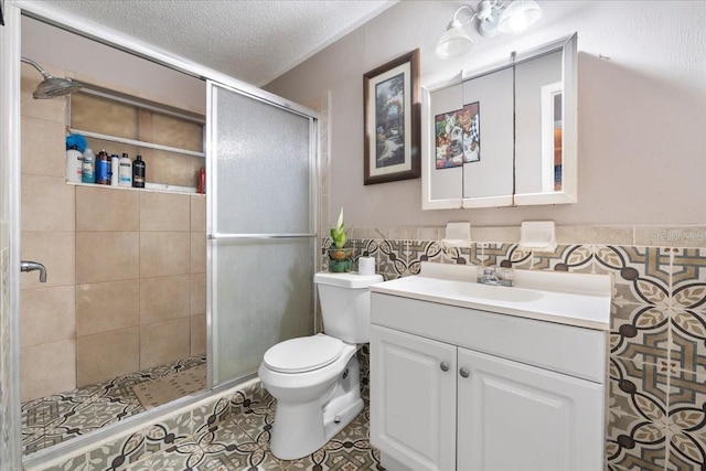 bathroom with a shower with door, tile patterned flooring, vanity, a textured ceiling, and toilet