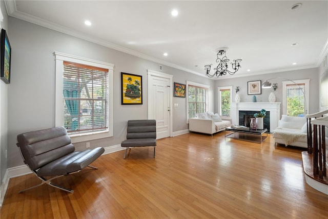 living area featuring ornamental molding, a notable chandelier, and light hardwood / wood-style floors