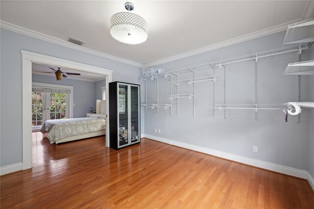 unfurnished bedroom featuring wood-type flooring, ornamental molding, and french doors