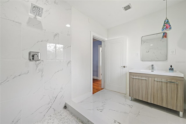 bathroom featuring vanity and tiled shower