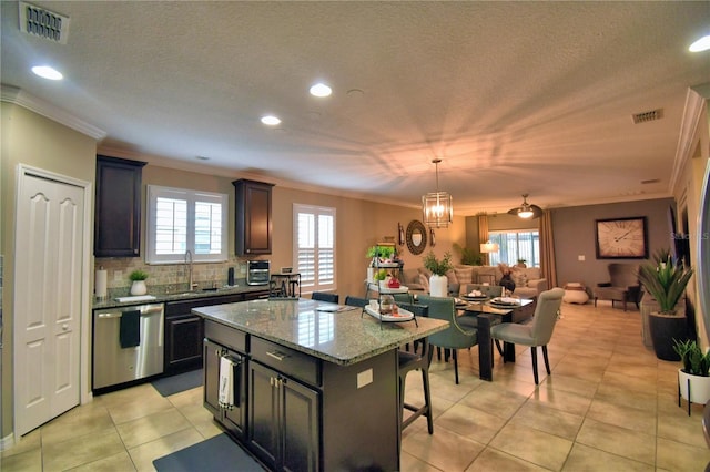 kitchen with pendant lighting, sink, a kitchen island, a kitchen bar, and stainless steel dishwasher