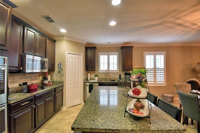 kitchen featuring appliances with stainless steel finishes, a center island, sink, and stone counters