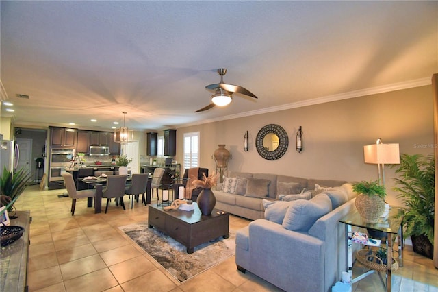 tiled living room featuring crown molding and ceiling fan with notable chandelier