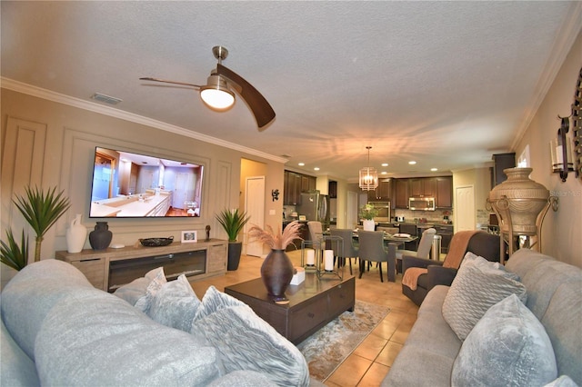 tiled living room featuring ceiling fan with notable chandelier, ornamental molding, and a textured ceiling