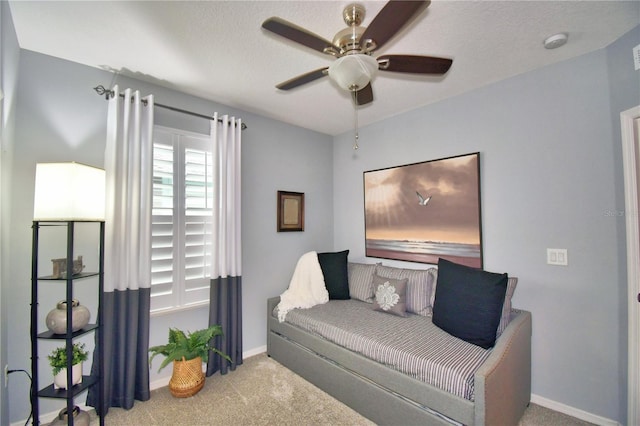 living area with light carpet and ceiling fan