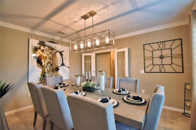 tiled dining room featuring ornamental molding and a chandelier