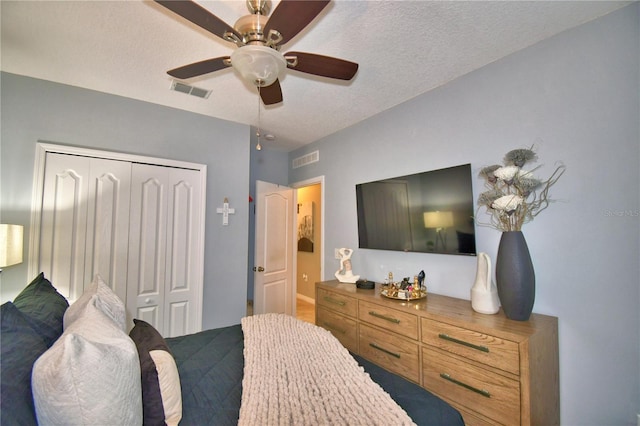 bedroom featuring ceiling fan, a closet, and a textured ceiling