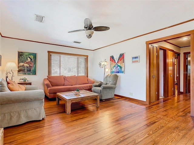 living room featuring crown molding, ceiling fan, and light wood-type flooring