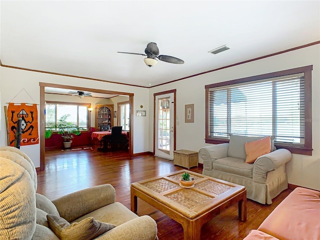 living room with crown molding, dark wood-type flooring, and ceiling fan