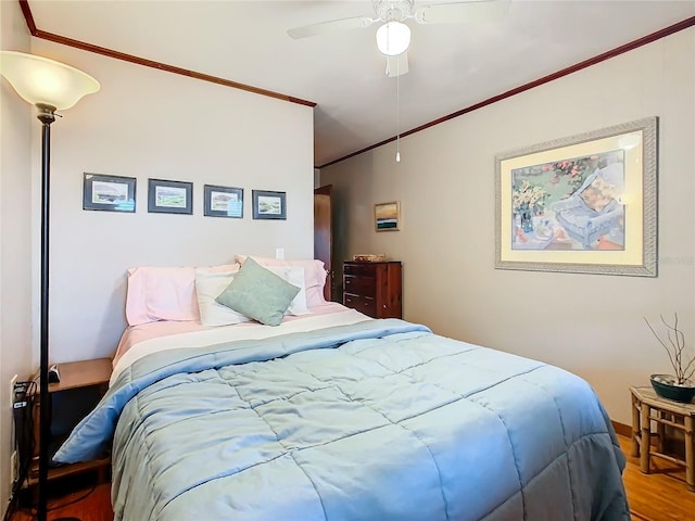 bedroom with hardwood / wood-style flooring, ornamental molding, and ceiling fan