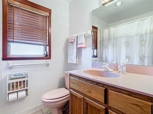 bathroom with a shower with curtain, vanity, toilet, and tile patterned flooring