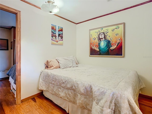 bedroom featuring wood-type flooring and ornamental molding