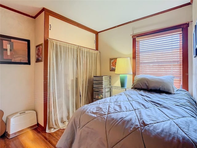 bedroom featuring crown molding and hardwood / wood-style flooring