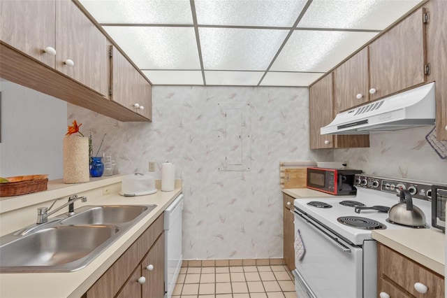 kitchen featuring a paneled ceiling, sink, light tile patterned floors, and white appliances