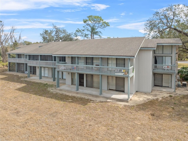 rear view of property featuring a lawn and a patio area