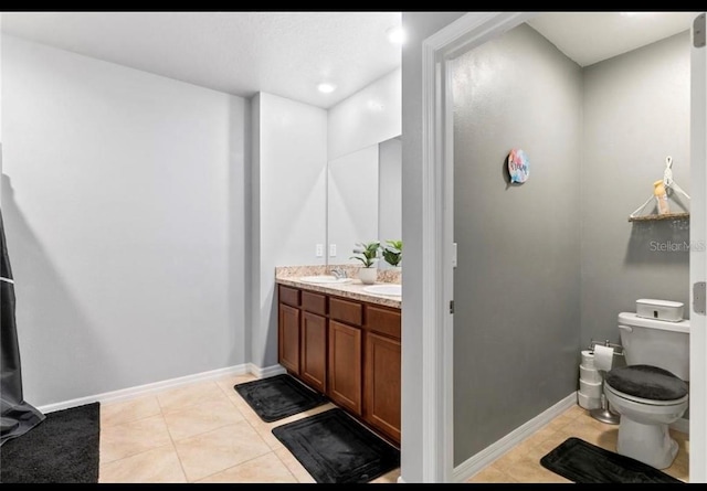 bathroom with tile patterned flooring, vanity, and toilet