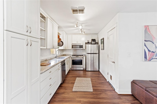 kitchen with sink, light stone countertops, white cabinets, and appliances with stainless steel finishes