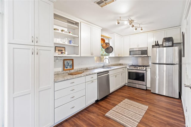 kitchen with sink, dark hardwood / wood-style floors, stainless steel appliances, light stone countertops, and white cabinets