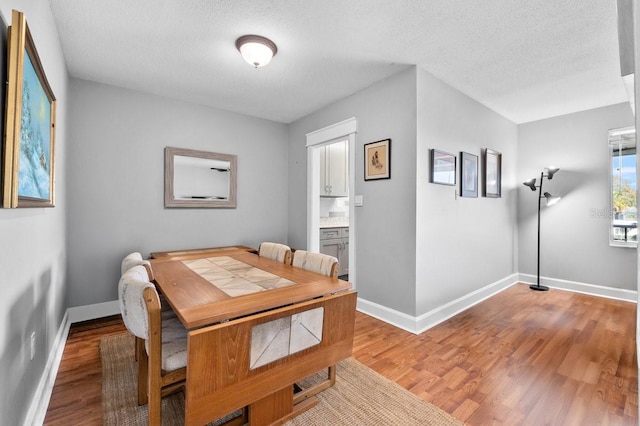 dining area featuring hardwood / wood-style flooring and a textured ceiling