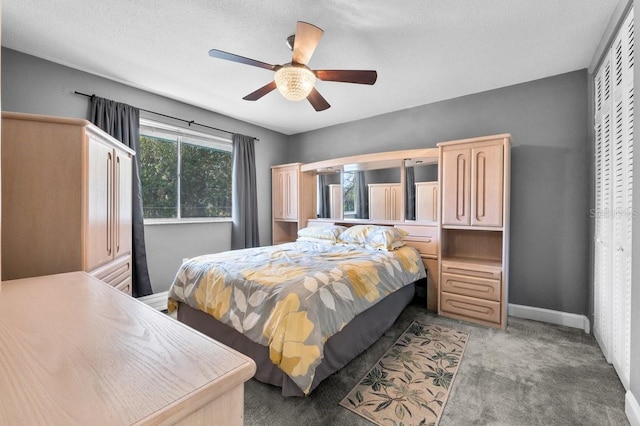 bedroom with ceiling fan, carpet floors, and a textured ceiling