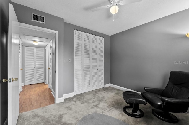 sitting room with light colored carpet and ceiling fan