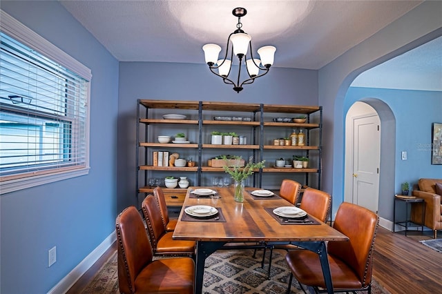 dining area with dark hardwood / wood-style floors, a chandelier, and a textured ceiling