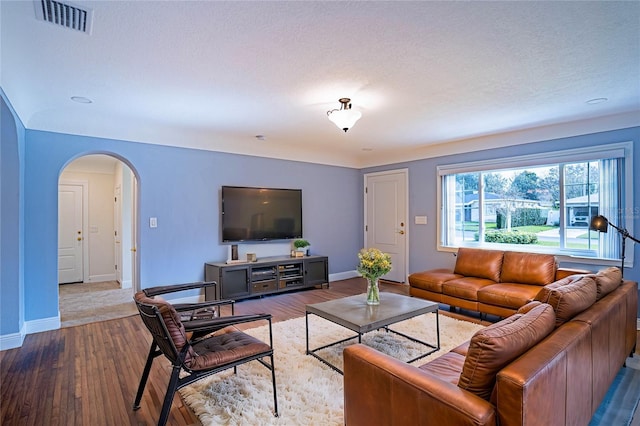 living room featuring a textured ceiling and light wood-type flooring