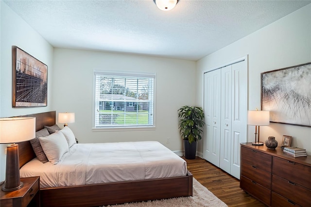 bedroom featuring dark wood-type flooring, a closet, and a textured ceiling