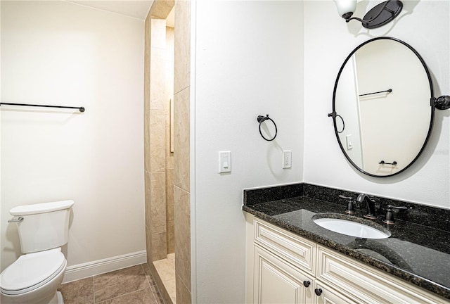 bathroom featuring walk in shower, vanity, toilet, and tile patterned flooring