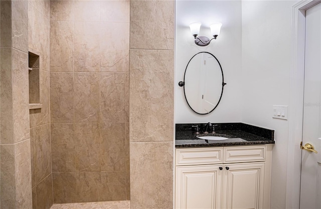 bathroom with vanity and a tile shower