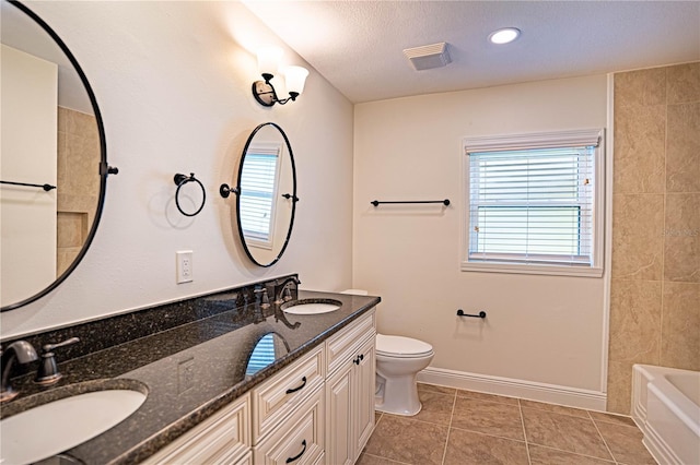 bathroom with tile patterned floors, vanity, toilet, and a textured ceiling