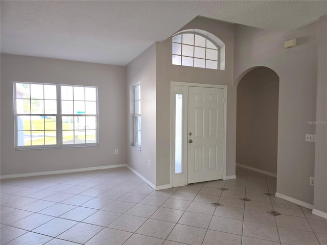 foyer entrance featuring light tile patterned floors and a textured ceiling