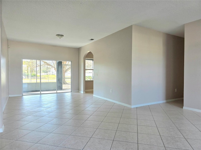 tiled spare room with a textured ceiling