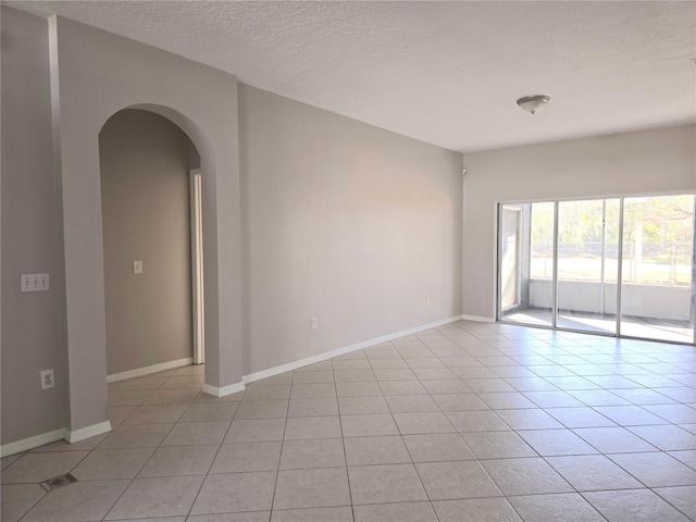 tiled spare room featuring a textured ceiling