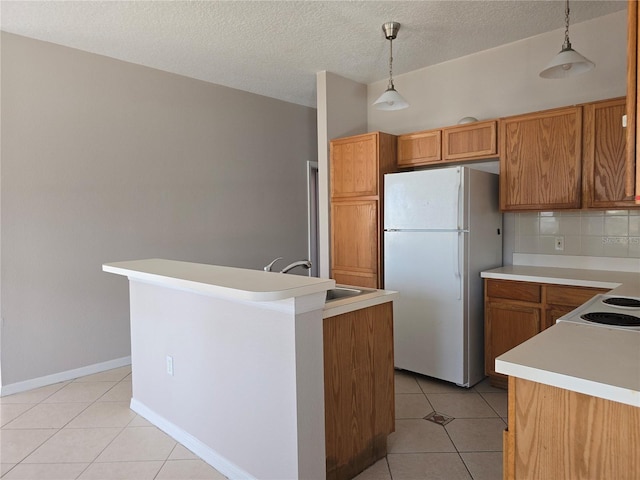 kitchen featuring a kitchen island, hanging light fixtures, white fridge, and light tile patterned floors