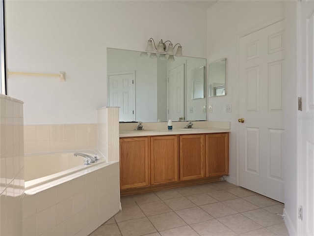 bathroom with tile patterned flooring, vanity, and tiled bath