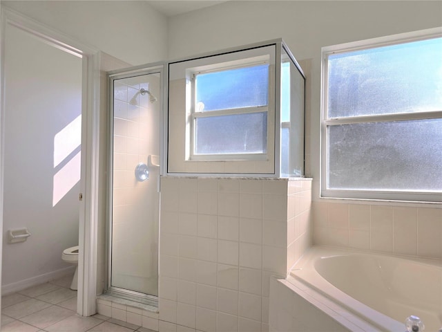 bathroom with tile patterned floors, toilet, and separate shower and tub