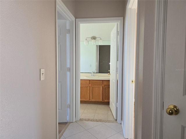 hallway featuring sink and light tile patterned floors