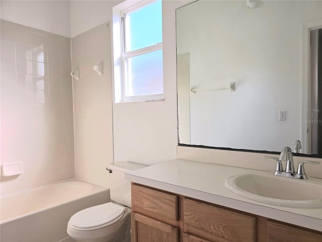 full bathroom featuring vanity, tiled shower / bath, and toilet