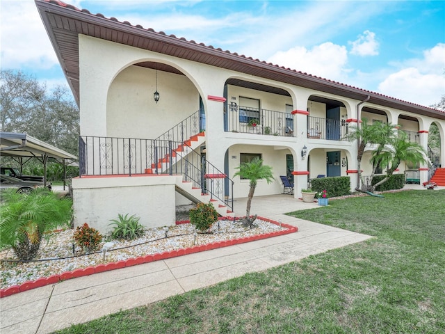 view of front of house with a front yard and a balcony