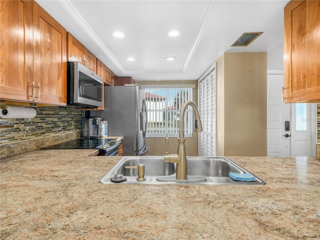 2002 Granada Ct Unit 1, Lake Wales, FL 33898 - kitchen with appliances with stainless steel finishes, sink, backsplash, a raised ceiling, and ornamental molding