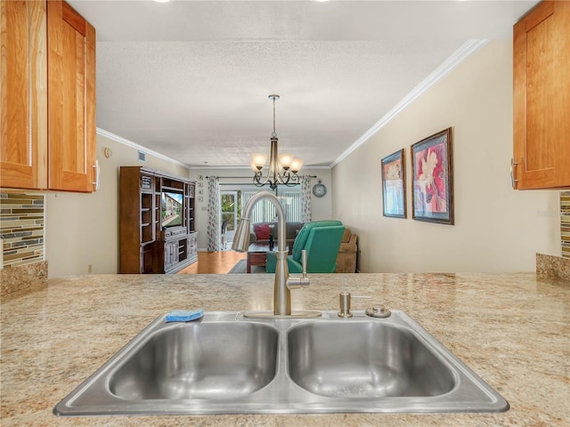 2002 Granada Ct Unit 1, Lake Wales, FL 33898 - kitchen featuring an inviting chandelier, sink, backsplash, a textured ceiling, and crown molding