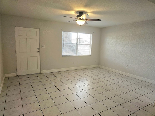 tiled empty room featuring ceiling fan and a textured ceiling