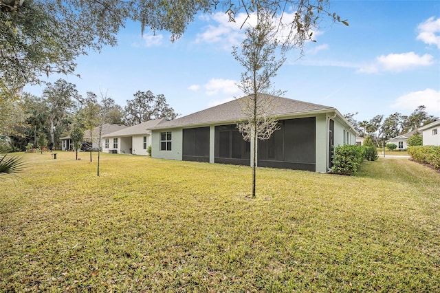 rear view of property featuring a sunroom and a lawn