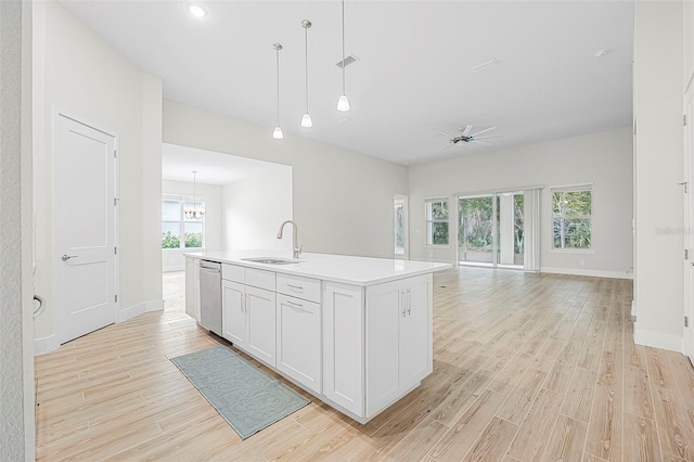 kitchen with white cabinetry, dishwasher, sink, an island with sink, and hanging light fixtures