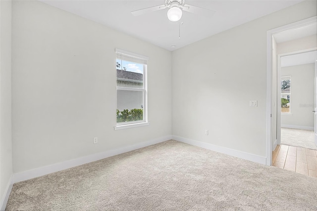 empty room with ceiling fan and light colored carpet